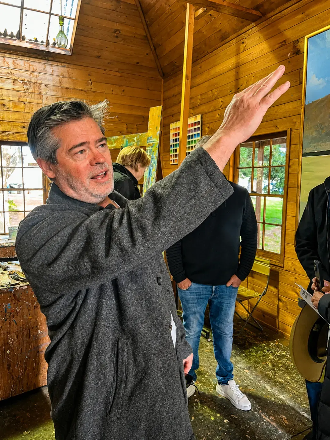 James McGrath speaking with one arm raised in Arthur Boyd's studio at Bundanon